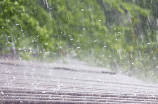 Rain falling on a residential roof, shown as a general weather illustration.
